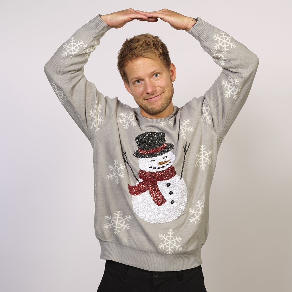 Un uomo che indossa un maglione di Natale grigio con un pupazzo di neve.